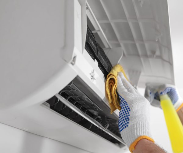 Service guy cleaning and maintaining air condition unit.